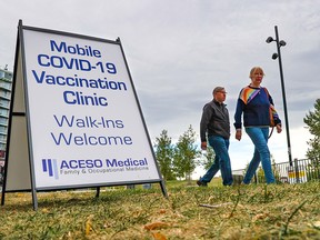 A signs marks a City of Calgary mobile COVID-19 vaccination clinic in Eau Claire near the Peace Bridge on Sept. 22, 2021.