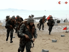 China's military releases an action film-style video of its soldiers in beach-landing and assault drills directly across the sea from Taiwan.