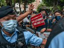 Police set up a barrier as pro-democracy activists protest in the Wan Chai district in Hong Kong on October 1, 2021.