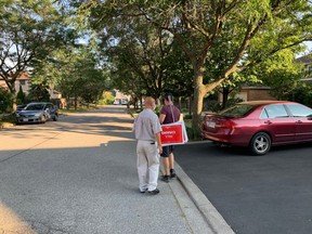 Liberal candidate Paul Chiang, left, puts up lawn signs with one of his staffers in the Ontario riding of Markham—Unionville, ahead of the 2021 election.