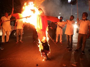 Protestors burn an effigy of Yogi Adityanath, Chief Minister of the northern state of Uttar Pradesh, during a protest after people were killed when a car linked to a federal minister on Sunday ran over farmers protesting against controversial farm laws in Uttar Pradesh.