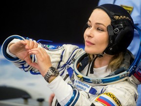 The International Space Station crew member Russian actor Yulia Peresild gestures after donning space suit before the launch at the Baikonur Cosmodrome, Kazakhstan.