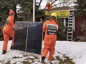 Greenpeace activists carry a solar panel to install on Alberta Premier Ralph Klein’s home in Calgary in 2002.