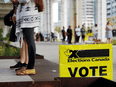 People line up outside a polling station in Toronto to vote in the federal election, September 20, 2021.