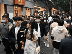People walk on a street in Beijing. There is evidence indicating that gay people in China “suffer significant levels of discrimination and intra-familial violence,” Justice John Norris said in his ruling.