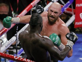 Tyson Fury (top) throws a right just before knocking out Deontay Wilder in the 11th round of their WBC heavyweight title fight at T-Mobile Arena in Las Vegas, Saturday, Oct. 9, 2021. PHOTO BY ETHAN MILLER