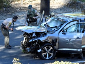 Los Angeles County Sheriff’s Deputies inspect the vehicle of golfer Tiger Woods, who was rushed to hospital after suffering multiple injuries in a single-vehicle accident in Los Angeles, California, U.S. February 23, 2021.