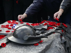 Members of the public lay poppies at the Tomb of the Unknown Soldier during Remembrance Day ceremonies in Ottawa on Friday, November 11, 2016.