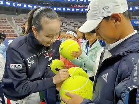 Chinese tennis player Peng Shuai signs oversized tennis balls at the Fila Kids Junior Tennis Challenger Final in Beijing, China November 21, 2021, in this screen grab obtained from a social media video.
