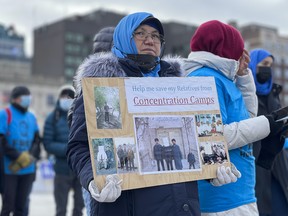 Tacinisahan Mahmut holds photographs of family members who have been jailed or who have disappeared in her native East Turkistan, in the northwestern part of China, during a Nov. 23, 2021, rally on Parliament Hill organized by the  Uyghur Rights Advocacy Project and East Turkistan Association of Canada.