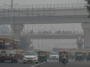 Commuters make their way along a street amid smoggy conditions in New Delhi on Nov. 5, 2021.