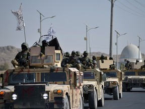 Taliban military from the Al-Badr unit sit on armed vehicles during a parade in Kandahar on November 8, 2021. (Photo by JAVED TANVEER/AFP via Getty Images)