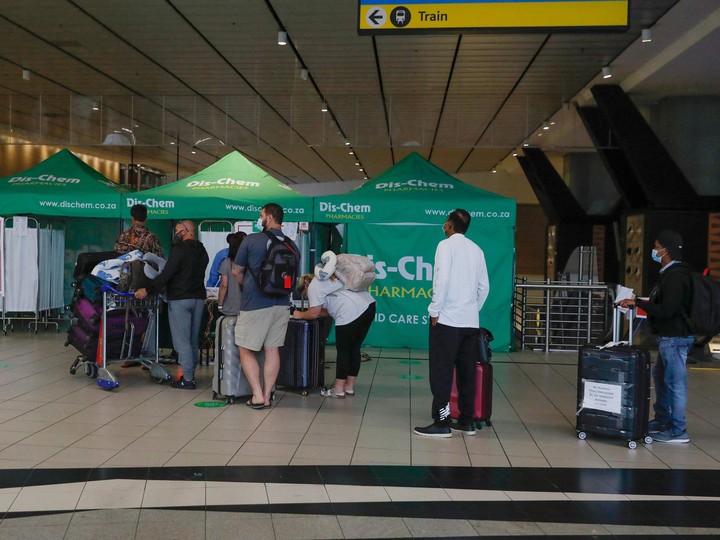  Travellers queue at an area for polymerase chain reaction (PCR) COVID-19 tests at OR Tambo International Airport in Johannesburg on Nov. 27, 2021.