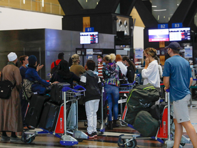 Travellers queue at a check-in counter at OR Tambo International Airport in Johannesburg, South Africa on Nov. 27, 2021. South Africa is one of several countries whose nationals are now subject to a travel ban by Canada.
