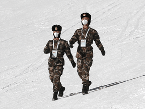 Paramilitary police officers patrol the slopes before an Olympic test skiing event in Zhangjiakou, China, on November 25, 2021.