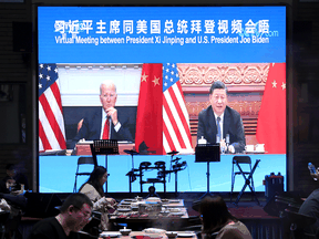 A screen at a Beijing restaurant shows U.S. President Joe Biden and Chinese President Xi Jinping during a virtual meeting on November 16, 2021.