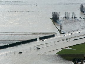 A convoy of trucks drives along the flooded Trans-Canada Highway after rainstorms caused flooding and landslides in Abbotsford, British Columbia, Canada November 17, 2021.