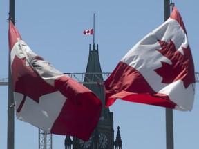 Canadian flags fly at half mast on the Peace tower and around the city Monday May 31, 2021 in Ottawa. The flags have been lowered indefinitely to recognize the discovery of children's remains at the former Kamloops Indian Residential school.