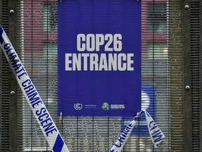 A tape reading "Climate crime scene" is placed by the entrance information sign for the UN Climate Change Conference (COP26) in Glasgow, on Nov. 12.