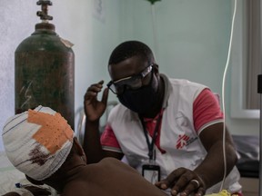 Surgeon checks on Princesse, 5, who was injured in the head by a stray bullet during clashes between gang members and police, as Haiti's fuel shortages continue to threaten the operations of medical facilities, in Port-au-Prince on Oct. 28, 2021.