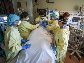 A health-care team in an ICU in Red Deer, Alta., move a COVID patient into the prone position.