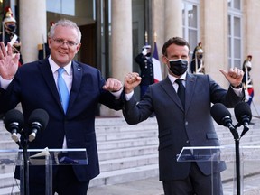 In this file photo taken on June 15, 2021 French President Emmanuel Macron (R) and Australia's Prime Minister Scott Morrison answer the press prior to a working diner at the Elysee Palace in Paris.