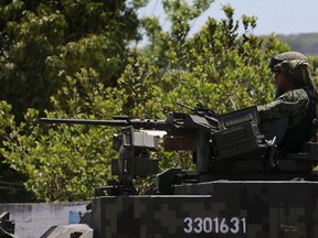 Mexican military guard a highway in Jalisco state, a base of operations for Jalisco New Generation Cartel (CJNG). AFP PHOTO/HECTOR GUERREROHECTOR