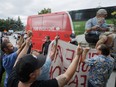 Demonstrators gesture towards a campaign bus as Prime Minister Justin Trudeau arrives at a campaign stop in Nobleton, Ont., on Aug. 27. Another campaign rally scheduled for that day in Bolton, Ont., was cancelled over security concerns.