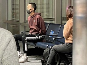 A man wearing a face mask and hoodie is restrained after an incident aboard an American Airlines flight which was diverted to Denver, Colorado, U.S. October 27, 2021.