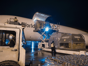 Airport ground crew offload a plane carrying the first shipment of the Pfizer-BioNTech COVID-19 vaccine, approved for children aged five to 11, in Hamilton, Ont., Nov. 21, 2021.
