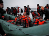 A group of more than 40 migrants with children get on an inflatable dinghy, as they leave the coast of northern France to cross the English Channel, near Wimereux, France, November 24, 2021.