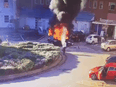 This image taken from surveillance camera video shows a man extinguishing a burning taxi following an explosion, outside Liverpool Women's hospital in Liverpool, England, on November 14, 2021. Authorities have declared the blast a terrorist incident.