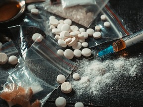 Hard drugs on dark table. Drug syringe and cooked heroin