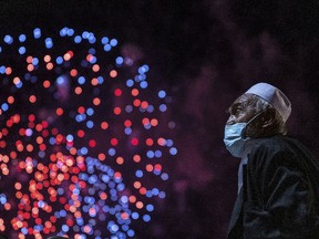 Ein Mann beobachtet, wie ein Feuerwerk den Himmel über dem Hafen von Sydney erhellt, während die Uhr am 01. Januar 2022 in Sydney, Australien, Mitternacht schlägt.