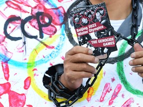 A card calling the 2022 Beijing Winter Olympics "The Genocide Games" is displayed as activists rally in front of the Chinese Consulate in Los Angeles, on Nov. 3.