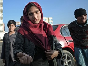 An Afghan girl begs on a street in Mazar-i-Sharif on Dec. 24, 2021. Abandoned by their Western allies, more than half of Afghanistan's population is facing potentially fatal levels of food insecurity before the end of winter, according to the UN World Food Program.