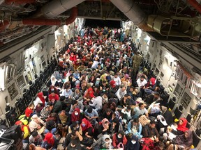 Evacuees termed Canadian Entitled Persons sit in a Royal Canadian Air Force (RCAF) C-177 Globemaster III transport plane for their flight to Canada from Kabul, Afghanistan, during the crisis on August 23, 2021. Canadian Armed Forces/Handout via REUTERS