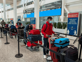 Passengers arriving at Pearson Airport in Toronto wait for transportation to their quarantine hotels, April 23, 2021.