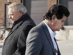 Ontario Premier Doug Ford, left, walks past Unifor President Jerry Dias at a press conference on November 2, 2021.