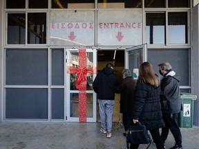 Clients queue outside a vaccination center to receive a Covid-19 vaccine in Thessaloniki, Greece, on Dec. 1, 2021