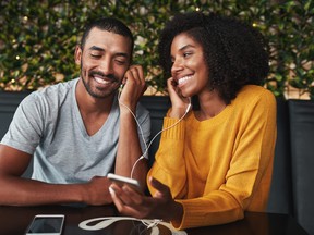 Couple together listening music in cafe smiling