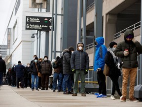 Die Leute stehen Schlange, um Antigen-Testkits für die Coronavirus-Krankheit (COVID-19) abzuholen, da die neueste Omicron-Variante als Bedrohung in der Yorkdale Mall in Toronto, Ontario, Kanada, 22.