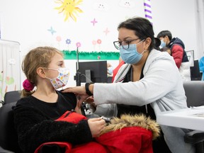 A nine-year-old receives her shot at a vaccination clinic after Canada approved Pfizer's COVID-19 vaccine for children aged five to 11, in Montreal, on Nov. 26