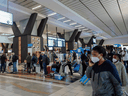 Travellers queue at a check-in counter at OR Tambo International Airport in Johannesburg on November 27, 2021, after several countries banned flights from South Africa following the discovery of a new COVID-19 variant Omicron.