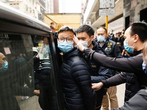 Patrick Lam, stellvertretender Chefredakteur von Stand News, einer der sechs Festgenommenen "wegen Verschwörung zur Veröffentlichung aufrührerischer Veröffentlichungen" wird nach Angaben der Nationalen Sicherheitsabteilung der Polizei von Hongkong von der Polizei begleitet, als sie das Büro verlassen, nachdem die Polizei sein Büro in Hongkong, China, am 29. Dezember 2021 durchsucht hatte.
