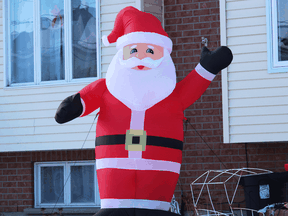 An inflatable Santa stands outside a home in Cornwall, Ontario.