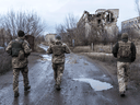 Ukrainian soldiers walk past destroyed buildings on the front line on December 8, 2021 in Marinka, Ukraine. A build-up of Russian troops along the border with Ukraine has heightened worries that Russia intends to invade the Donbas region, most of which is held by separatists.