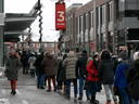 People line up outside an Ottawa hockey arena to receive their COVID-19 booster shots, Monday, Dec. 20, 2021.