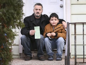 Mounin Yacoub is shown with his son Fauzi, 7, on Tuesday, December 7, 2021 at his Windsor home along with a $6,255 fine he received when he crossed the border back into Canada with the wrong COVID-19 test.