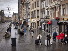 People walk on a quiet street in the centre of Amsterdam as Netherlands goes back into a COVID-19 lockdown on December 19, 2021. The Netherlands announced a Christmas lockdown and London declared a "major incident" as Europe tries to rein in rising COVID-19 case numbers and the highly mutated Omicron strain takes hold.